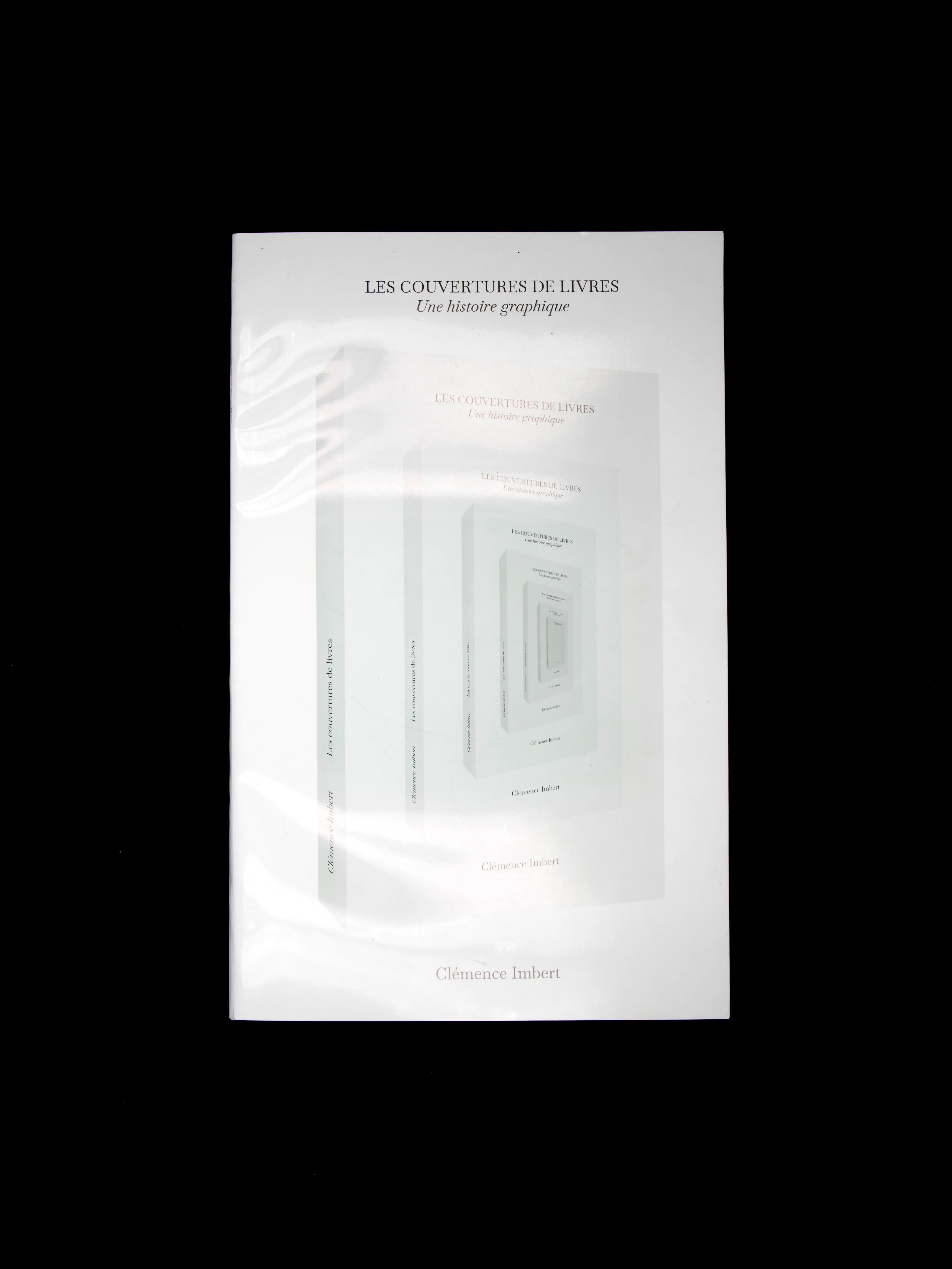 Livre Les couvertures de livres fermé, avec une mise en abyme de sa couverture blanche sur fond noir.