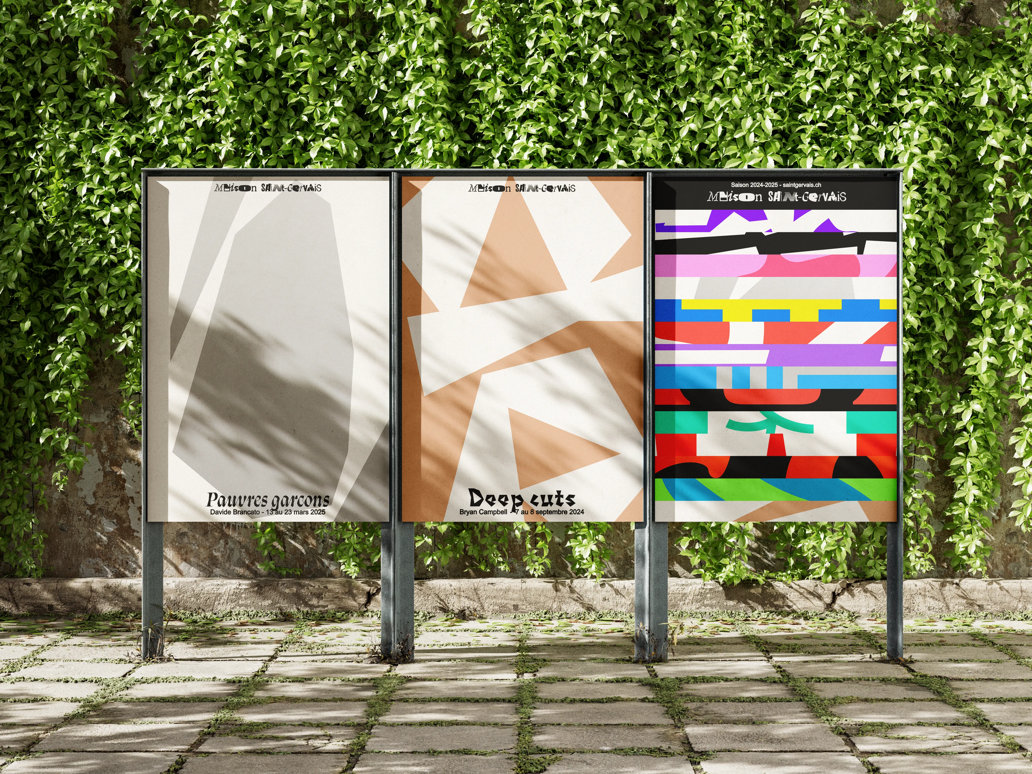 Trois affiches Maison Saint Gervais sur des panneaux devant un mur couvert de végétation.